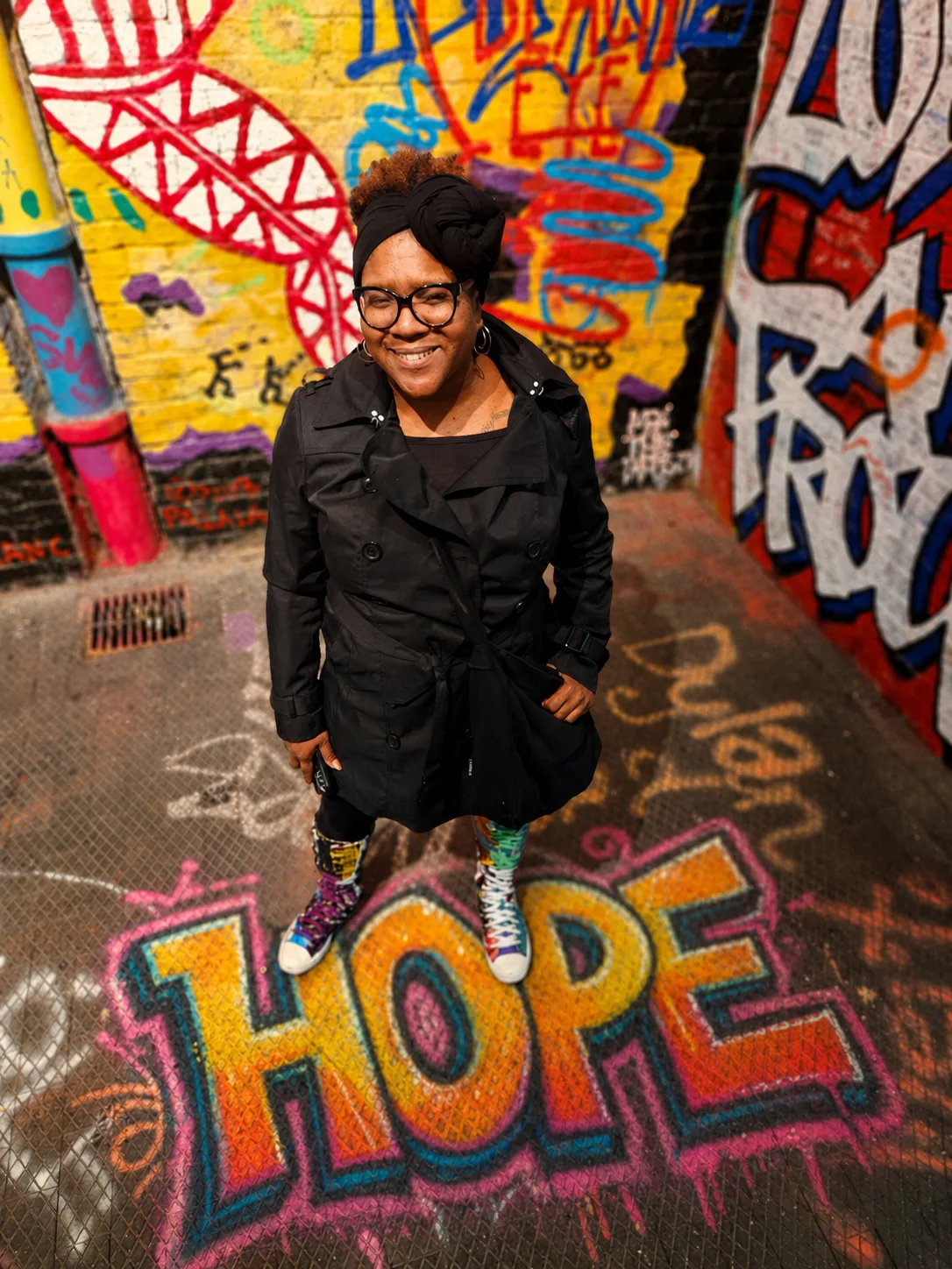 Dori LeGrand-Christmas standing above colorful HOPE graffiti artwork